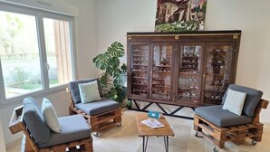 Un salón acogedor con dos sofás de madera, una mesa de centro y un aparador con puertas de cristal.