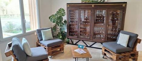 Un salón acogedor con dos sofás de madera, una mesa de centro y un aparador con puertas de cristal.