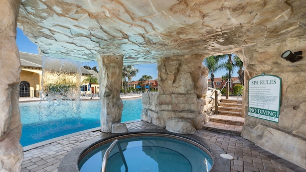 A spa area with a hot tub, a pool, and a sign indicating 'SPA RULES' and 'NO DIVING'. - Modern 5BR Retreat w/ Pool and Clubhouse Access (Kissimmee)