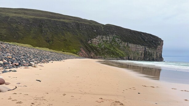 A beach with a rocky shoreline and a cliff. - Withi-gill - Bay of Ireland Views 50m From Beach (Stromness)