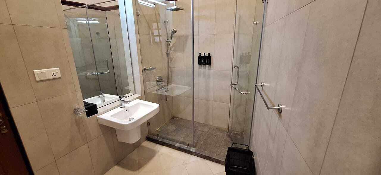 A modern bathroom with a glass-enclosed shower, a sink, and a mirror.