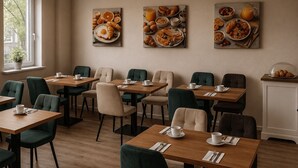Un espace repas avec des tables, des chaises et des œuvres d’art murales représentant des aliments.
