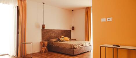 Un dormitorio moderno con cabecera de madera, cama con cubierta marrón, una mesita de noche de madera y una mesita de noche de metal.