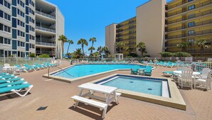 A pool area with multiple pools, lounge chairs, and a picnic table. - Top of the Gulf by Book That Condo (Panama City Beach)