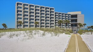 A multi-story hotel with a sandy pathway leading to the entrance. - Top of the Gulf by Book That Condo (Panama City Beach)