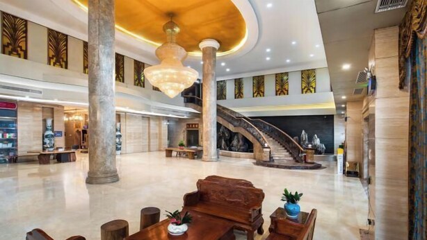 A spacious lobby with a grand staircase, wooden furniture, and a chandelier. - Jun Yi Kai Di Hotel (Shenzhen International Convention and Exhibition Center) (Shenzhen)