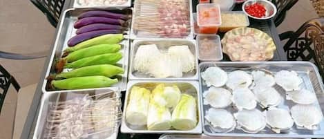 Variedad de mariscos y verduras expuestos en bandejas en un mercado.