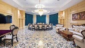 A formal dining room with a chandelier, a round table, and ornate chairs. - Jun Yi Kai Di Hotel (Shenzhen International Convention and Exhibition Center) (Shenzhen)