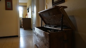 Un couloir avec un banc en bois, un radiateur et un tableau encadré accroché au mur.