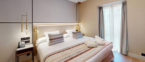 Quarto de hotel moderno com cama grande, abajures, telefone e vista para o exterior.