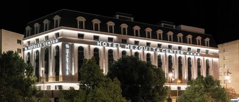 Ein Hotel im klassischen Stil mit Bogenfenstern und einem zentralen Eingang.