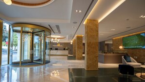 Eine moderne Hotellobby mit einer Doppeltür, einer Rezeption und einer Sitzecke.