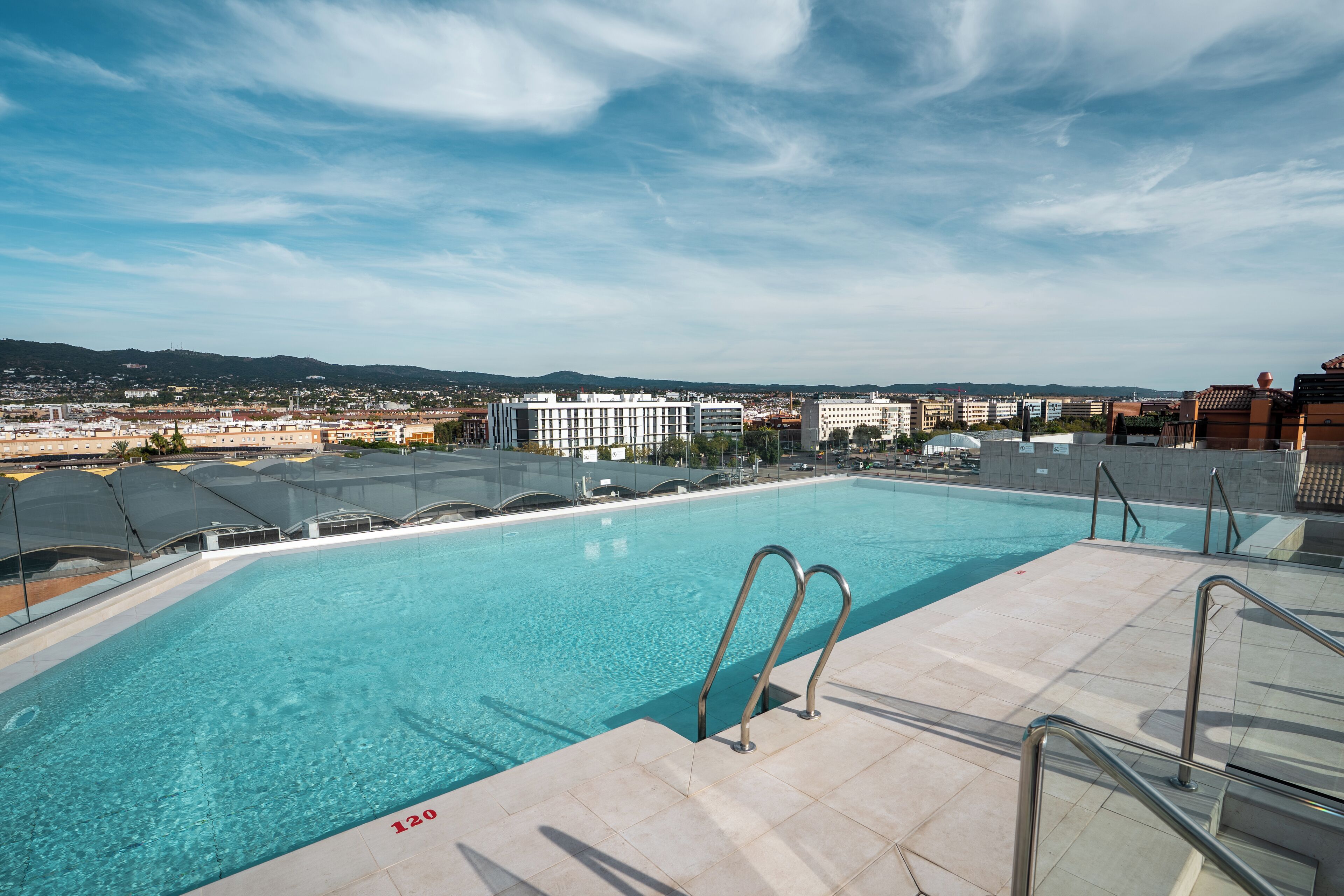 Una piscina al aire libre de temporada, sombrillas, tumbonas