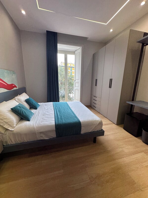 Une chambre moderne avec un lit, une armoire et une vue sur l’extérieur.