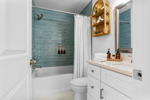 Un baño moderno con bañera, inodoro y tocador.