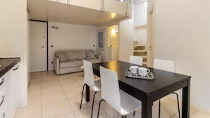 Un espace de vie compact comprenant un coin repas, une kitchenette et un canapé.