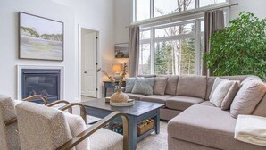 A living room with a sofa, armchairs, a coffee table, and a fireplace.