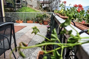 A patio with outdoor furniture, potted plants, and a view of a mountain. - Casa di Spino (Molina)