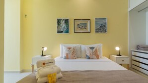 A bedroom with a bed, two bedside tables, and three wall-mounted artworks. - Comfort 4 minutes from Leblon Beach | AP801 (Rio de Janeiro)