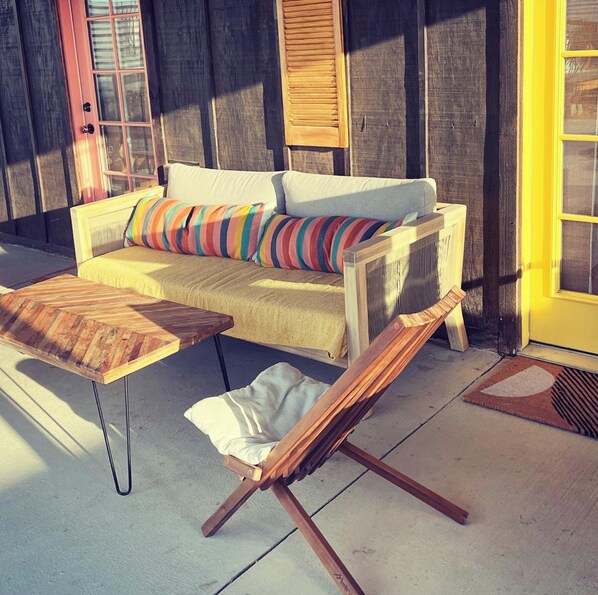 A cozy outdoor seating area with a sofa, a wooden table, and a lounge chair. - Desert Bliss Joshua Tree -Cowboy Pool & Tub. close to Pappy & Harriet's & Park. (Joshua Tree)