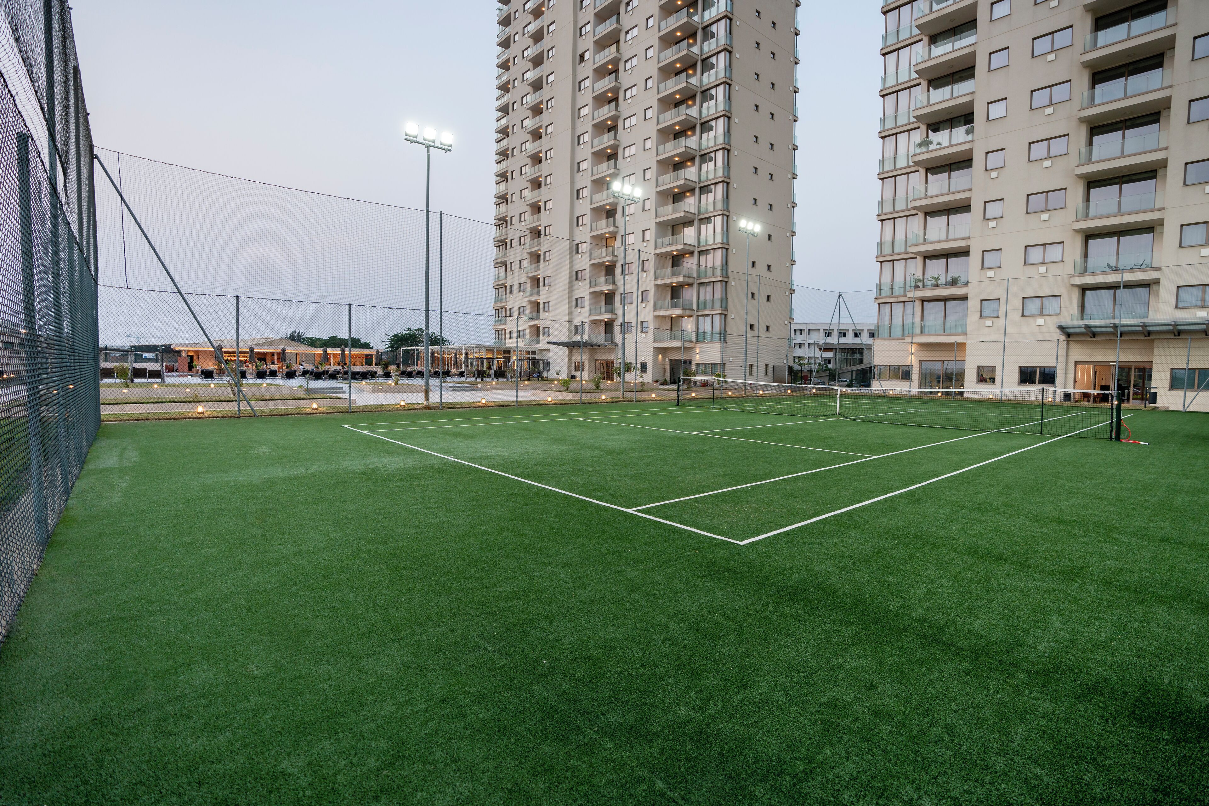 A tennis court surrounded by high-rise buildings.