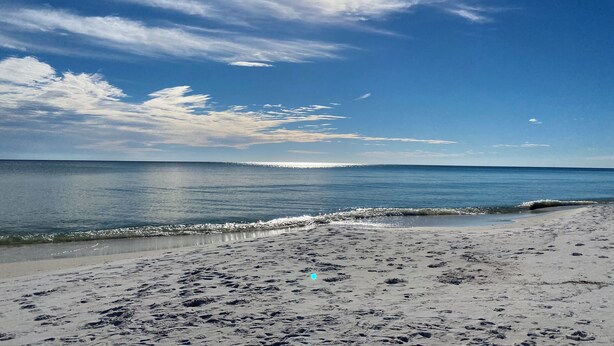 A beach with footprints leading to the water, a clear sky, and the sun shining. - Charming 2 bedroom townhome in Seagrove steps to the beach! (Santa Rosa Beach)