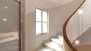 A modern staircase with a wooden handrail and a glass balustrade.