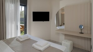 A modern hotel room with a large bed, a flat-screen TV, a mirror, and a view of the outdoors.