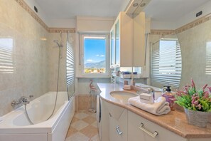 Une salle de bain moderne avec une baignoire, un lavabo et un grand miroir.