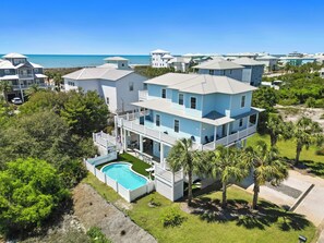 Une vaste propriété en bord de mer, comprenant plusieurs étages, une piscine, de nombreux balcons et une vue sur l’océan.