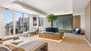 Un moderno vestíbulo de hotel con un amplio espacio de descanso, una planta y vistas a la ciudad.