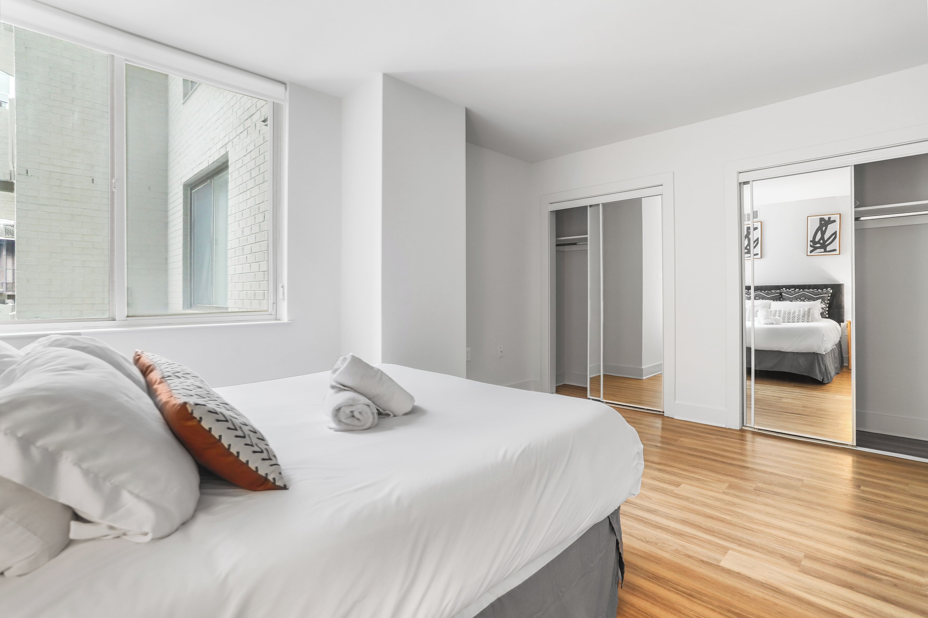 Une chambre moderne avec un grand lit, une armoire et un placard à portes coulissantes.