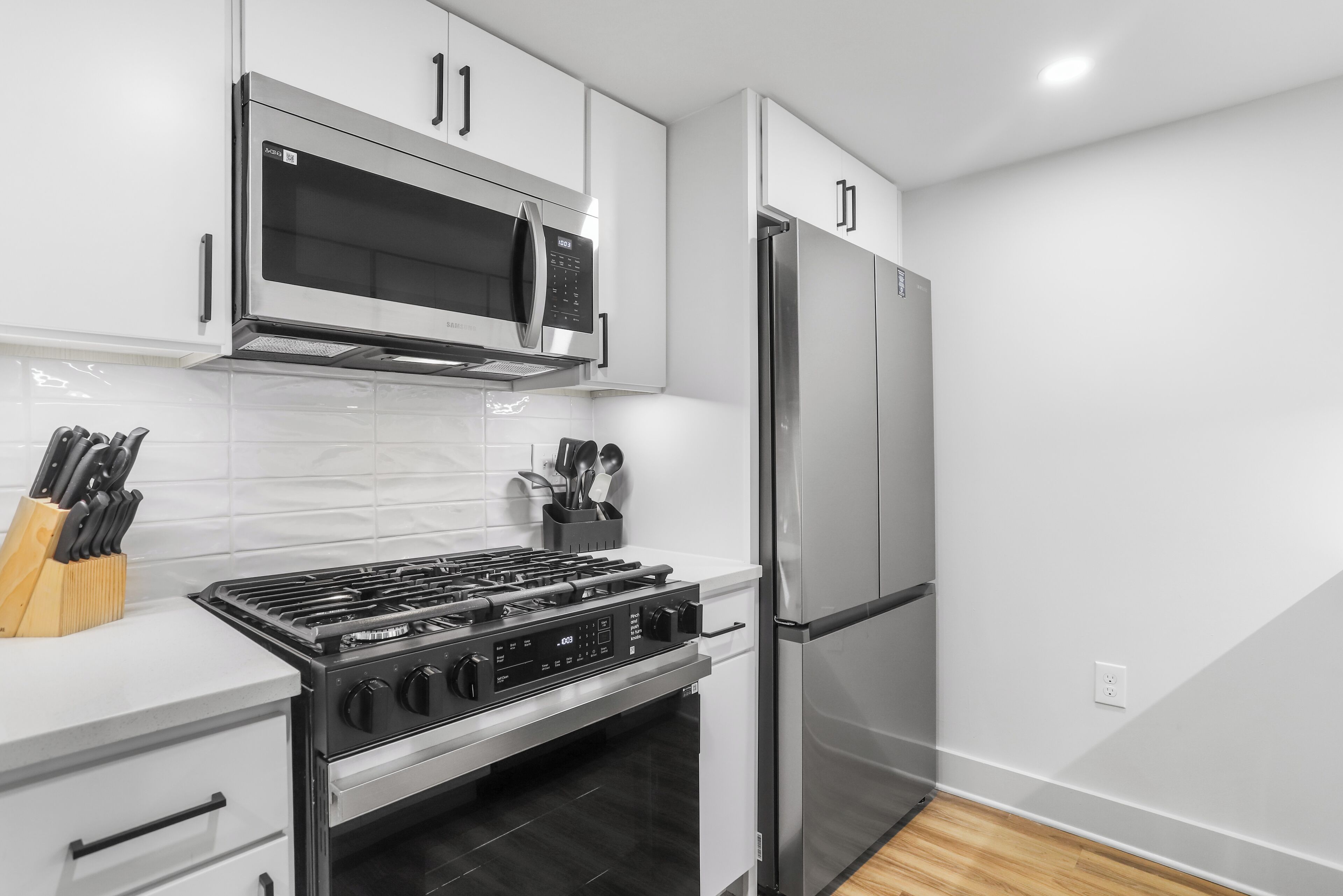 A modern kitchen with stainless steel appliances, including a microwave, refrigerator, and stove.