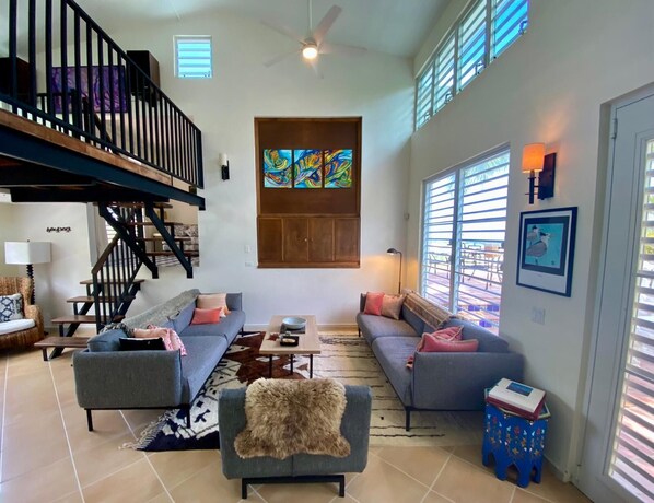 A spacious living room with a staircase, a large window with blinds, a colorful abstract painting, and a small table with a lamp. - LAS TERRAZAS
Wonderful 6-bedroom villa with gorgeous pool in tropical Vieques (Vieques)