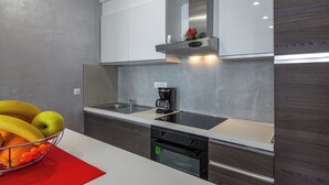 A modern kitchen with a white countertop, stainless steel appliances, and a built-in oven. - Charming 1-bedroom apartment in lovely Cavtat (Cavtat)