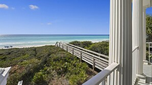 Un balcon avec vue sur la plage et l’océan.