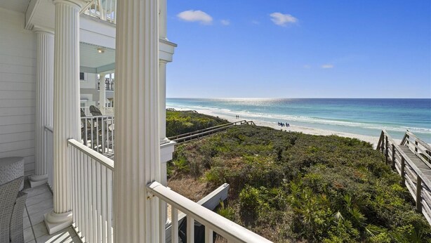 Un balcon avec vue sur la plage et l’océan.