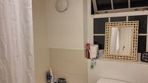 Ein Badezimmer mit Badewanne, Toilette und einem Spiegel mit dekorativem Rahmen.