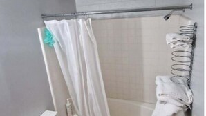 Een badkamer met douche, toilet en wastafel.