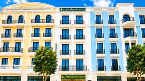 A multi-story hotel with a prominent entrance, large windows, and balconies.