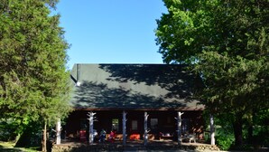 A rustic building with a covered porch, stone steps, and a gravel driveway. - Spacious 5-bedroom lodge in Flippin Ar, on the beautiful White River. (Flippin)
