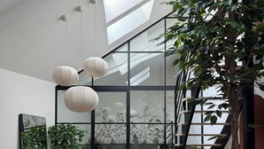 En modern inredning med ett matområde, en trappa och ett stort fönster.