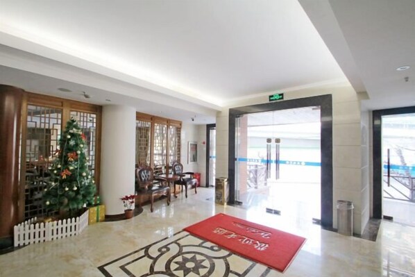 A hotel lobby with a Christmas tree, a reception desk, and a red carpet. - Yanrui Hotel (Shanghai)