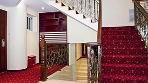 A staircase with a red carpet and metal railings.