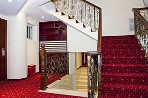A staircase with a red carpet and a metal railing. - Yanrui Hotel (Shanghai)