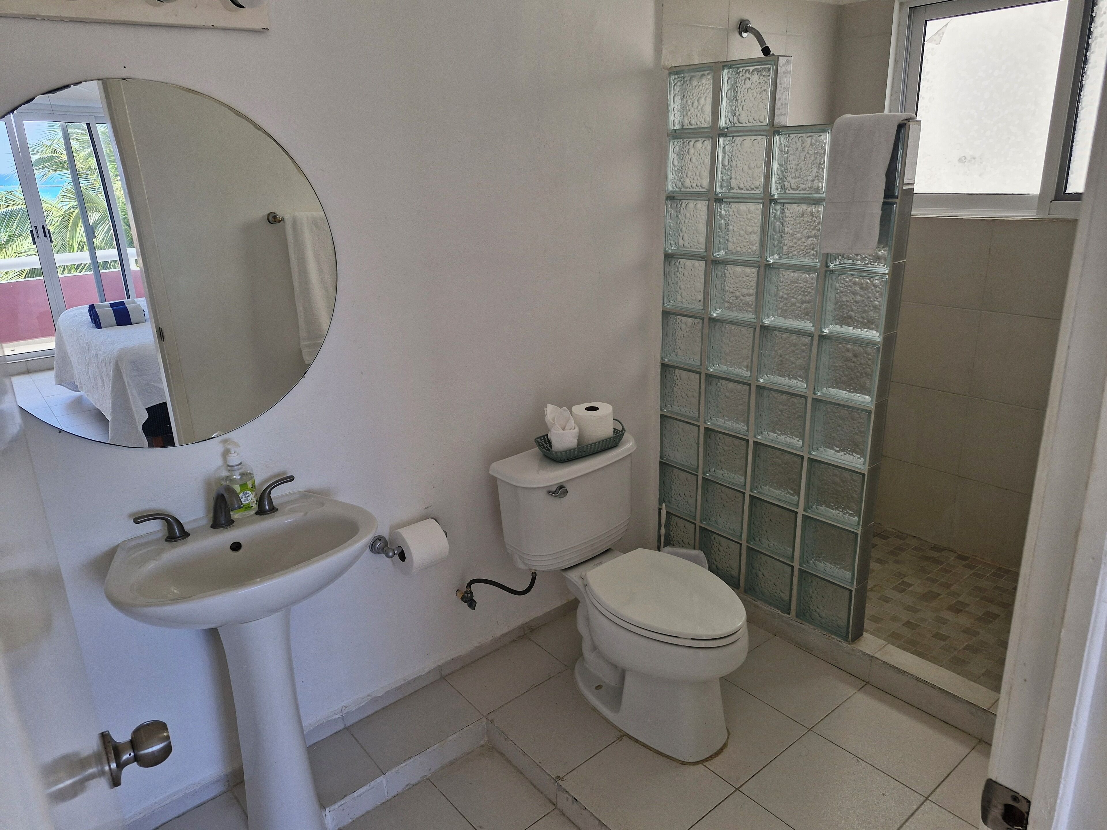 A bathroom with a sink, toilet, and glass shower enclosure.