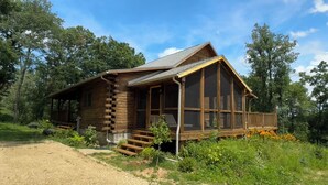A log cabin with a porch and a screened porch area, surrounded by greenery. - Beautiful Log House  4 Bed, 2 Baths, 15 acre land, close to Madison, sleeps 13 (Albany)
