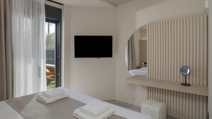Een moderne hotelkamer met een groot bed, een flatscreen televisie, een spiegel en een houten plank.