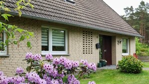Una casa con techo inclinado, fachada de ladrillo y un pequeño porche delantero.