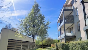 A modern apartment building with a two-story balcony and a tree in the courtyard. - Le Salluste: T2 cosy with balcony in Strasbourg. (Strasbourg)